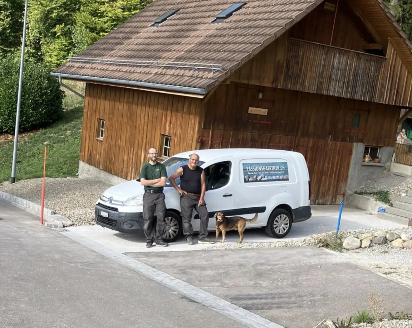 Das Team von Passionsgärtner mit Hund vor dem Firmenfahrzeug